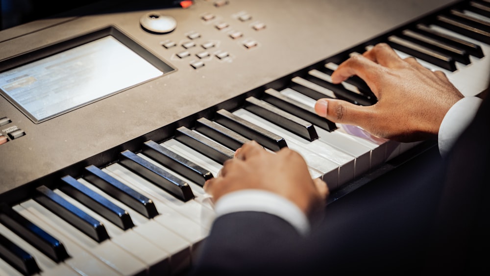 a man is playing a keyboard with his hands