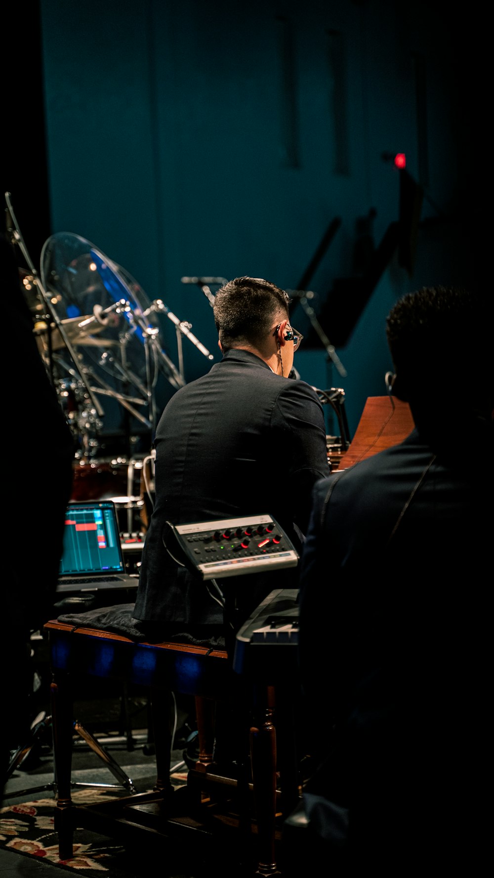 a man sitting in front of a keyboard in a recording studio