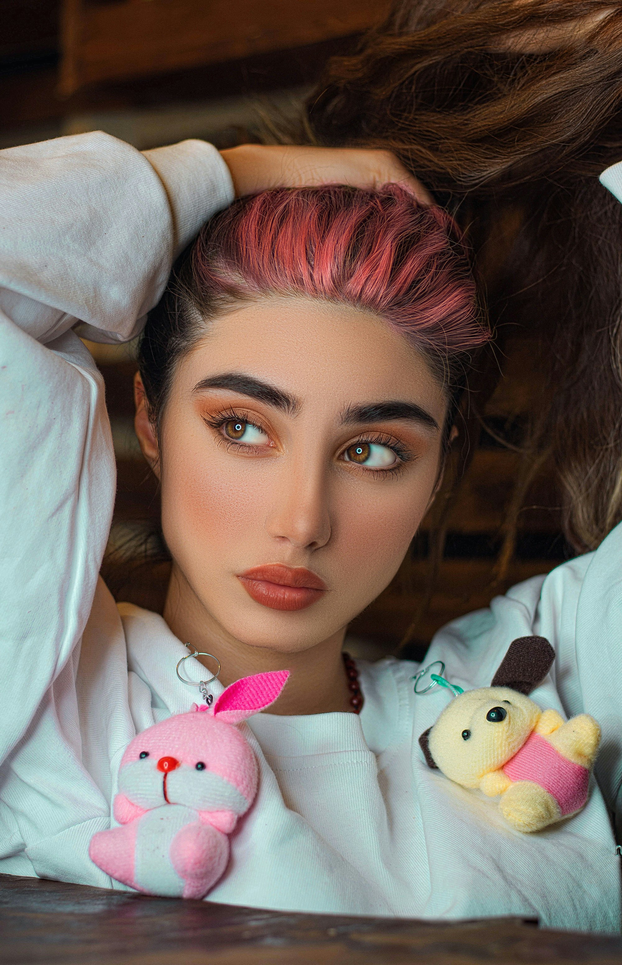 A woman with pink hair holding a stuffed animal photo – Free Iran Image