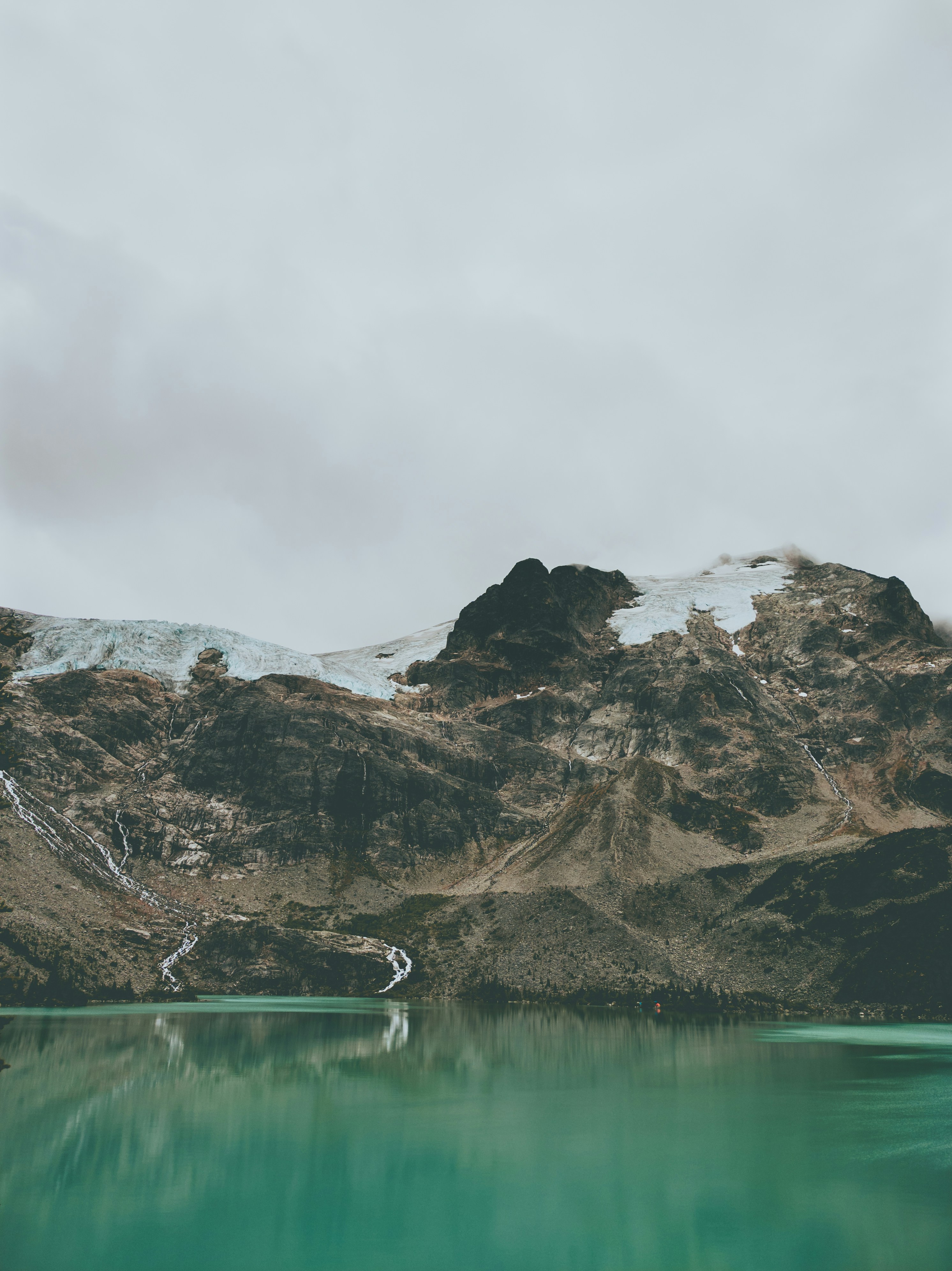 a mountain range with a lake in the foreground