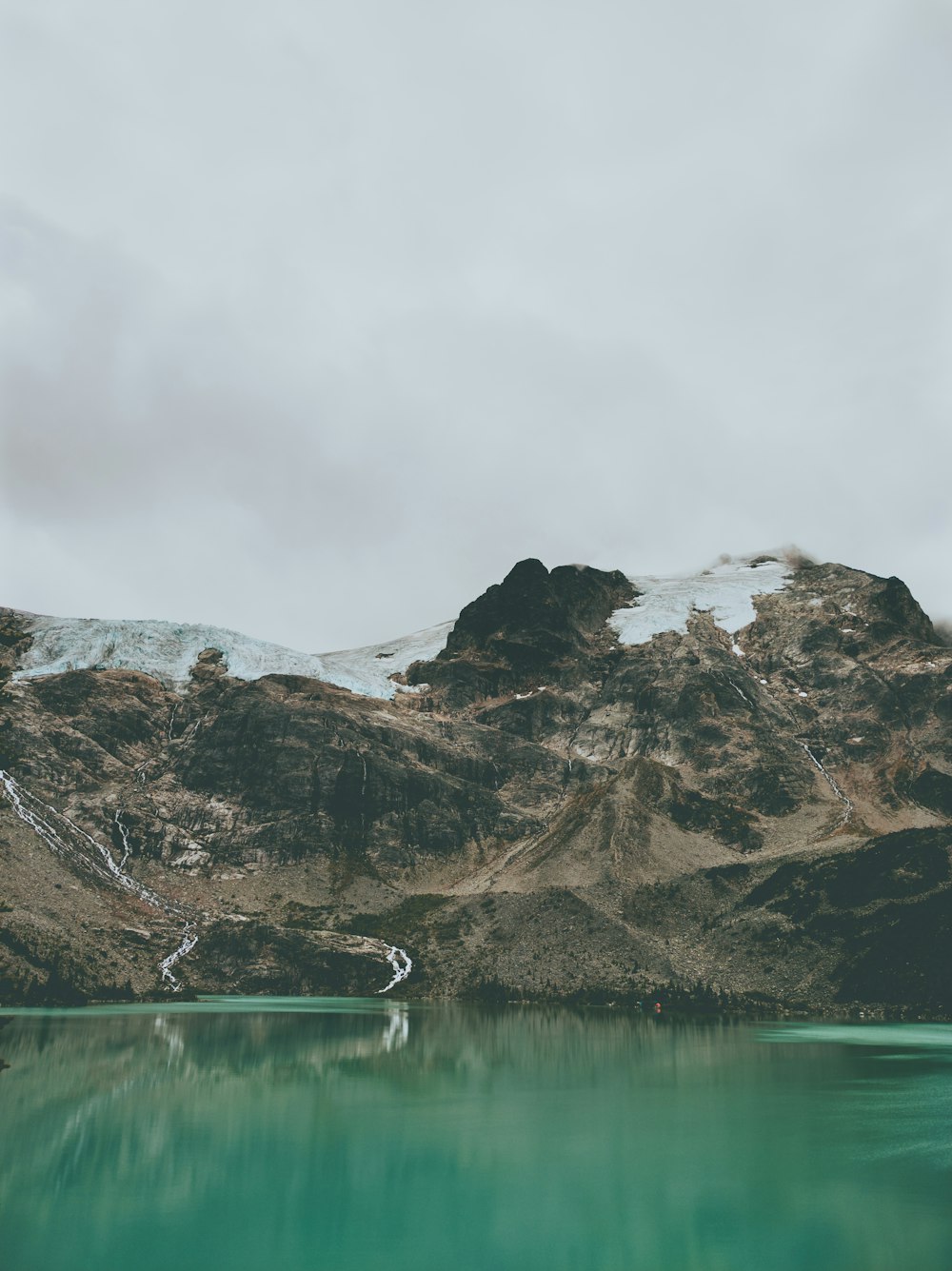 a mountain range with a lake in the foreground