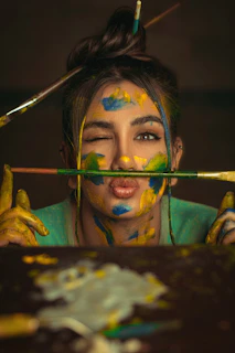 a woman with her face painted yellow and blue