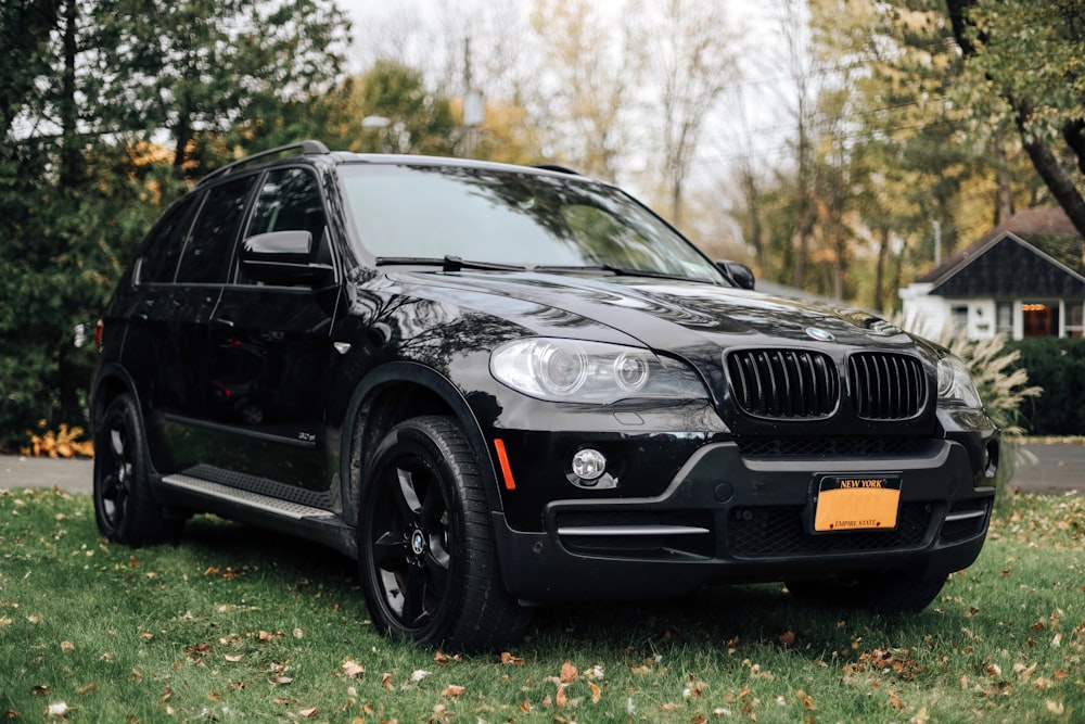 Un BMW X5 negro estacionado al costado de la carretera