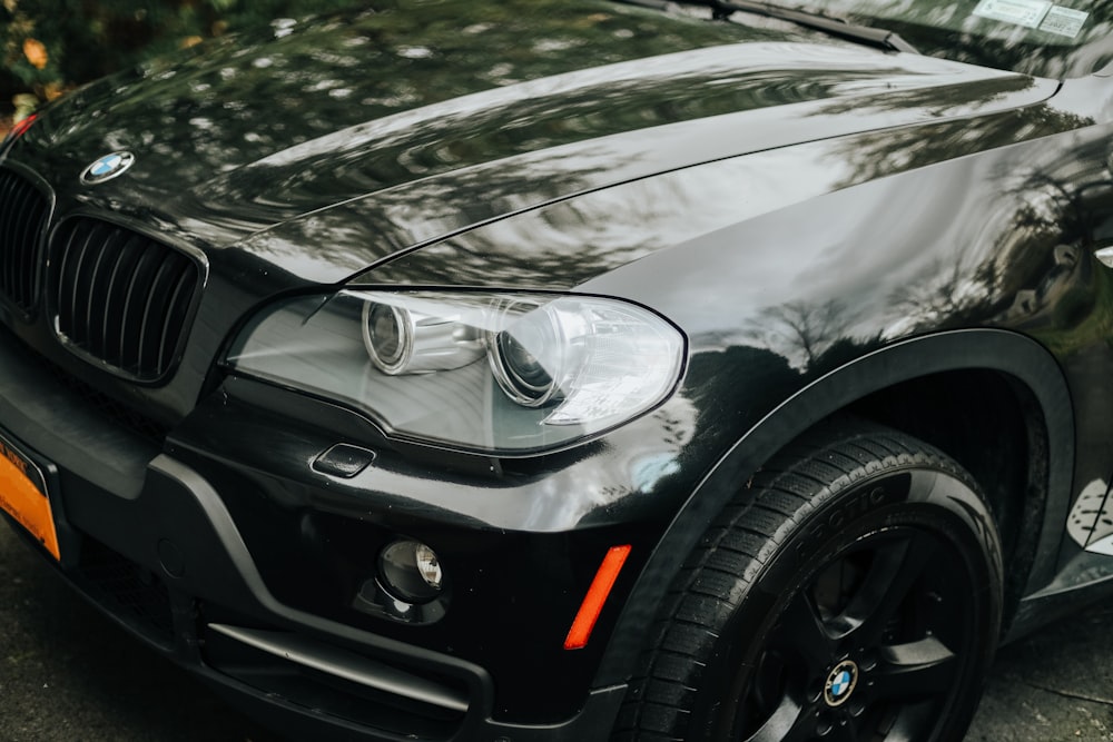 a black bmw suv parked on the side of the road