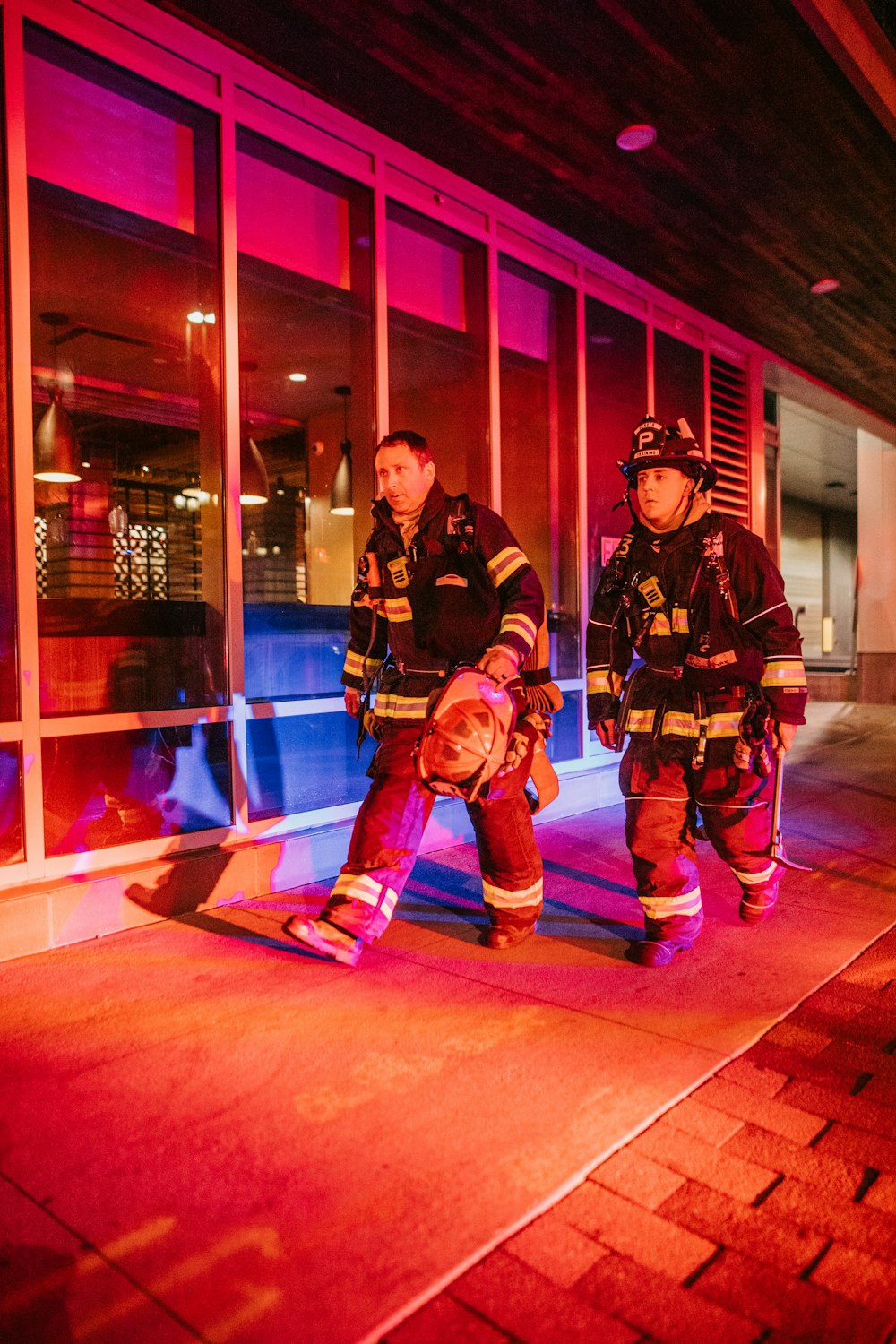 a couple of fire fighters standing next to each other