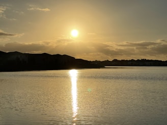Sunset view over the serene lake beside Lake Court Residence, with soft golden light reflecting on the water.