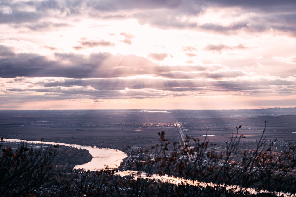 the sun shines through the clouds over a river