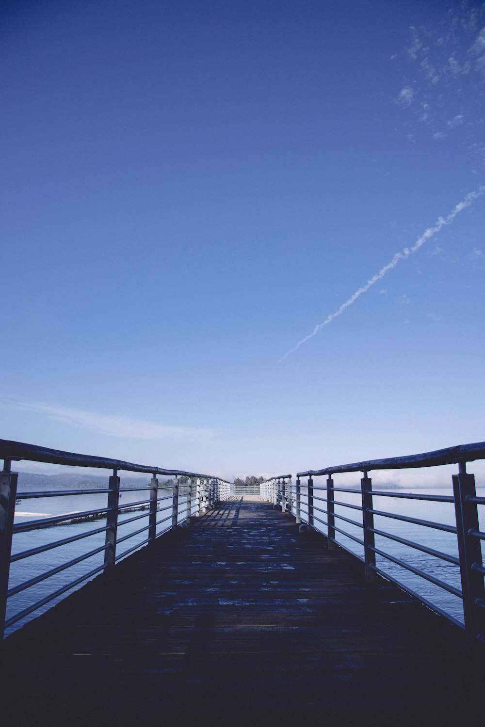 a long pier with a sky in the background