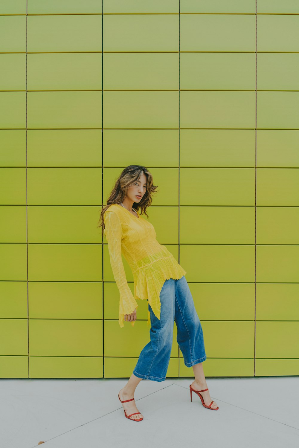 a woman standing in front of a green wall
