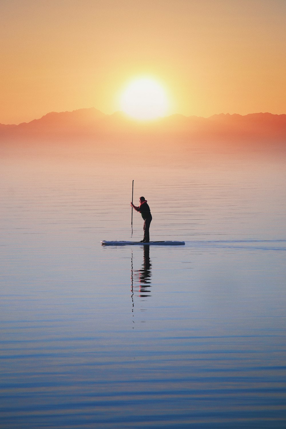 Una persona en una tabla de paddle en el agua