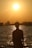 a person standing in the water at sunset