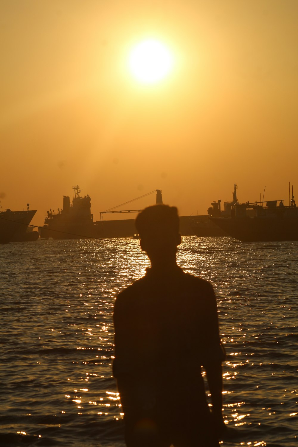 a person standing in the water at sunset