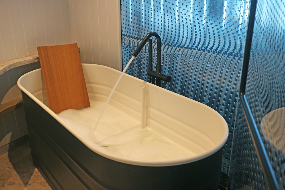 una vasca da bagno bianca seduta accanto a una cabina doccia