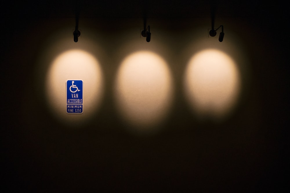 three lights that are on the side of a wall
