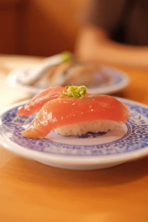 Close-up of a vibrant sushi platter with colorful garnishes on a rustic wooden table
