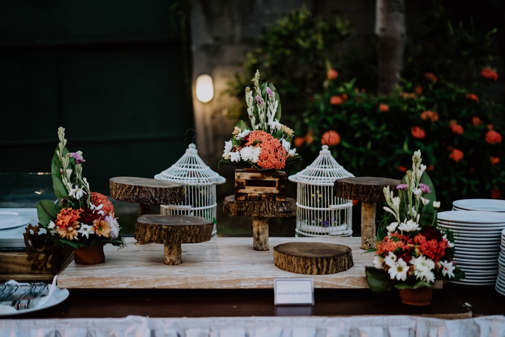 a table topped with a birdcage filled with flowers