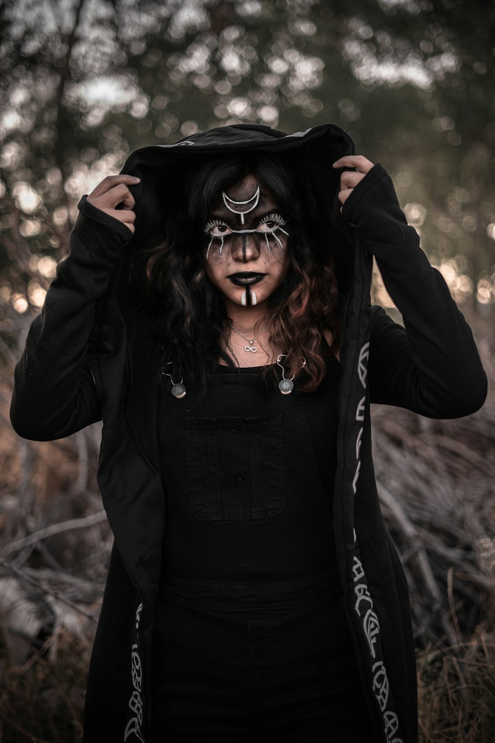a woman with face paint and a hoodie