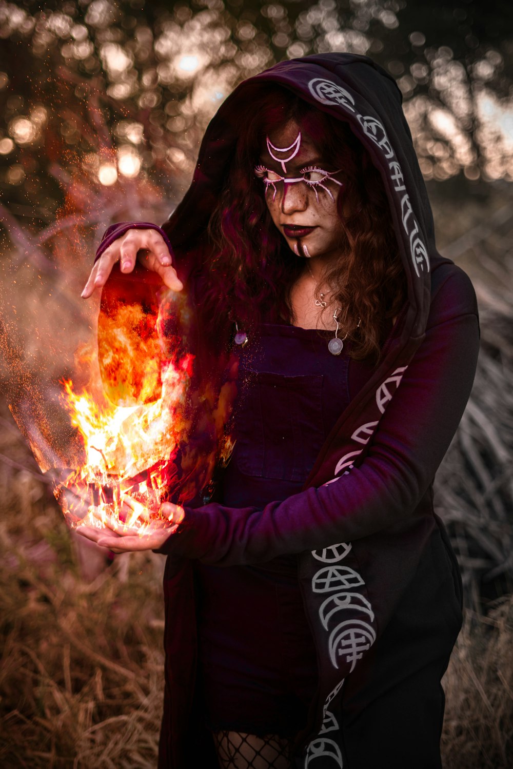 a woman in a costume holding a fire ball