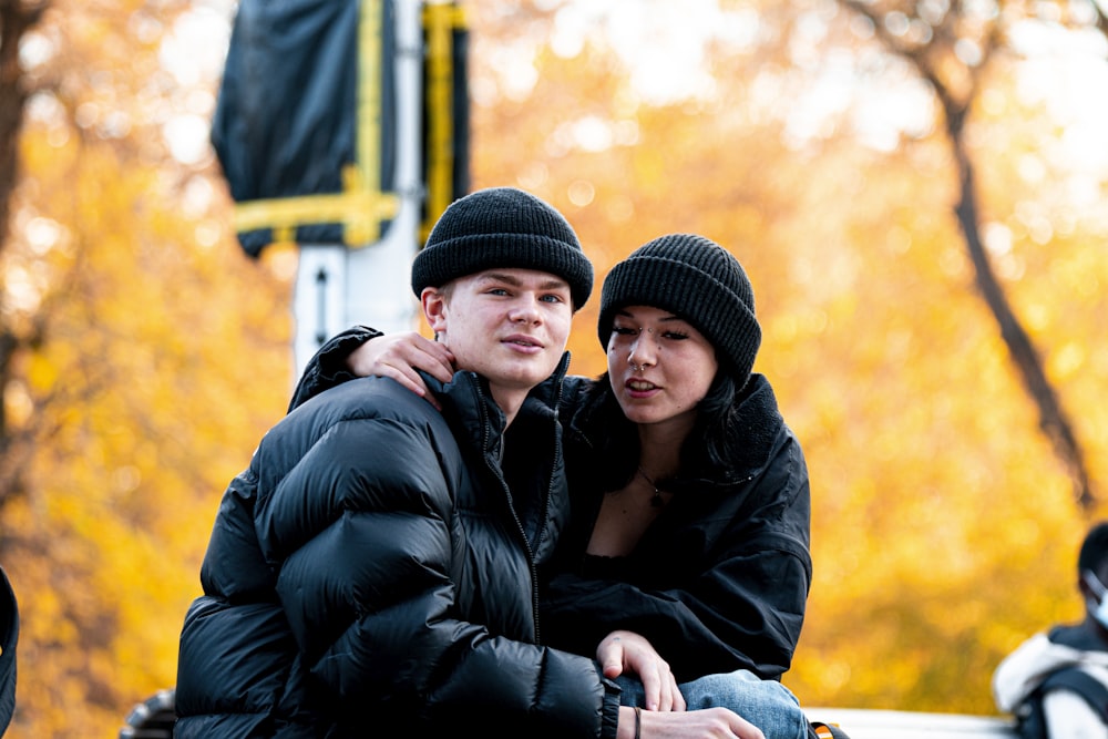 a man and a woman sitting on a park bench