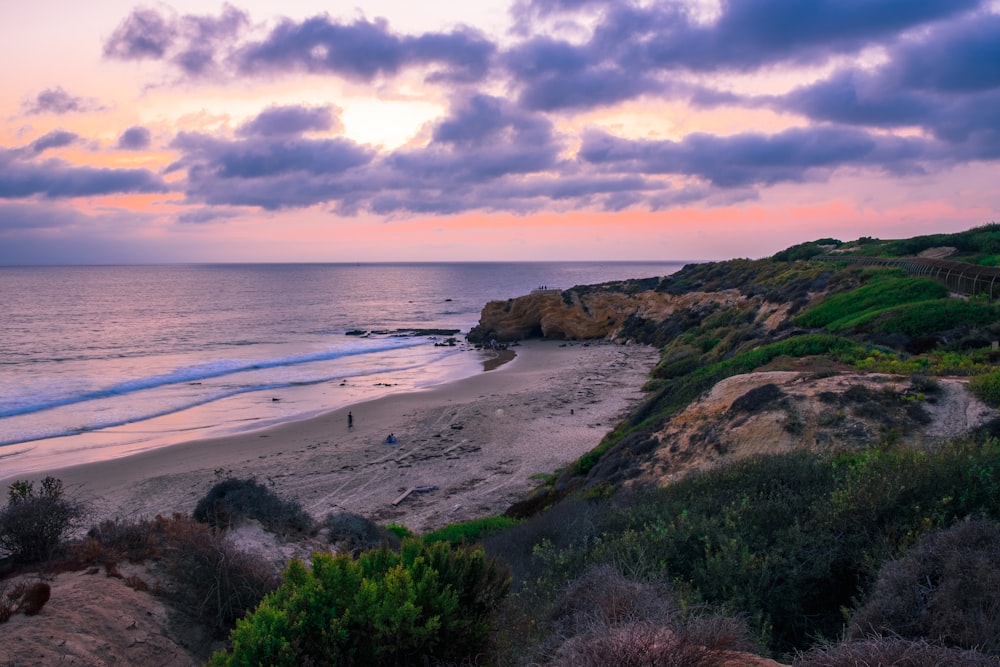 a sunset view of a beach and a body of water