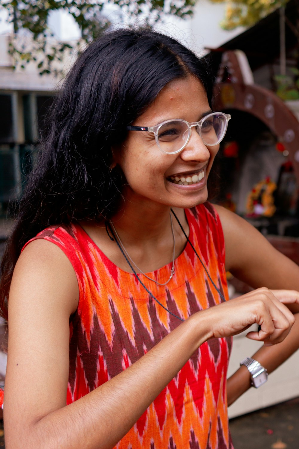 a woman wearing glasses is smiling and holding a cell phone