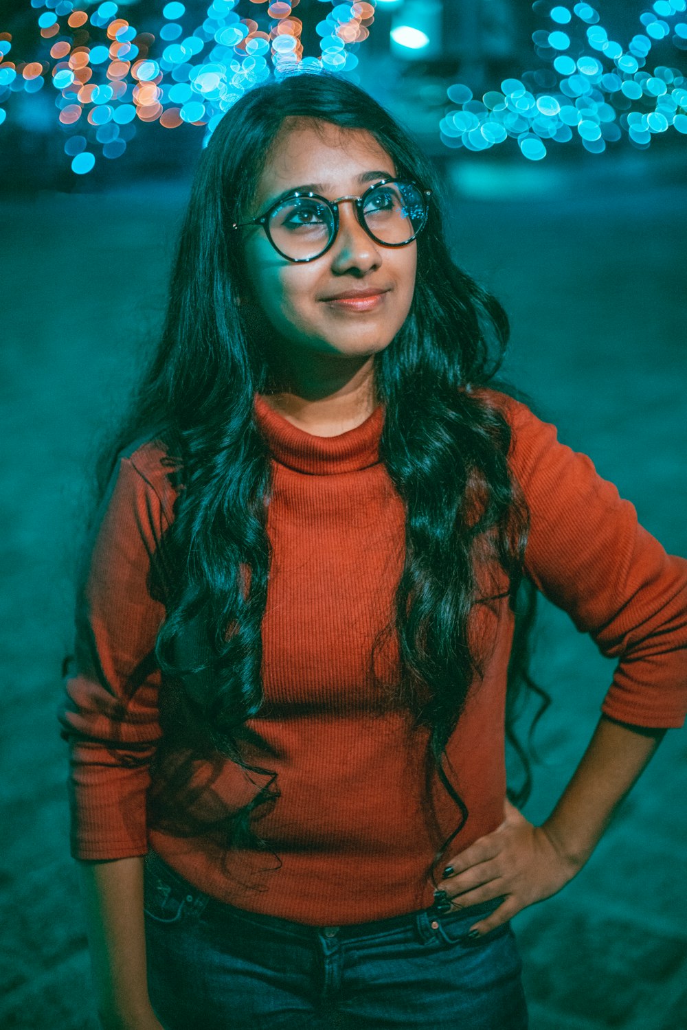 a woman wearing glasses standing in front of a building