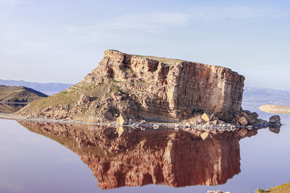 a large rock sitting in the middle of a lake