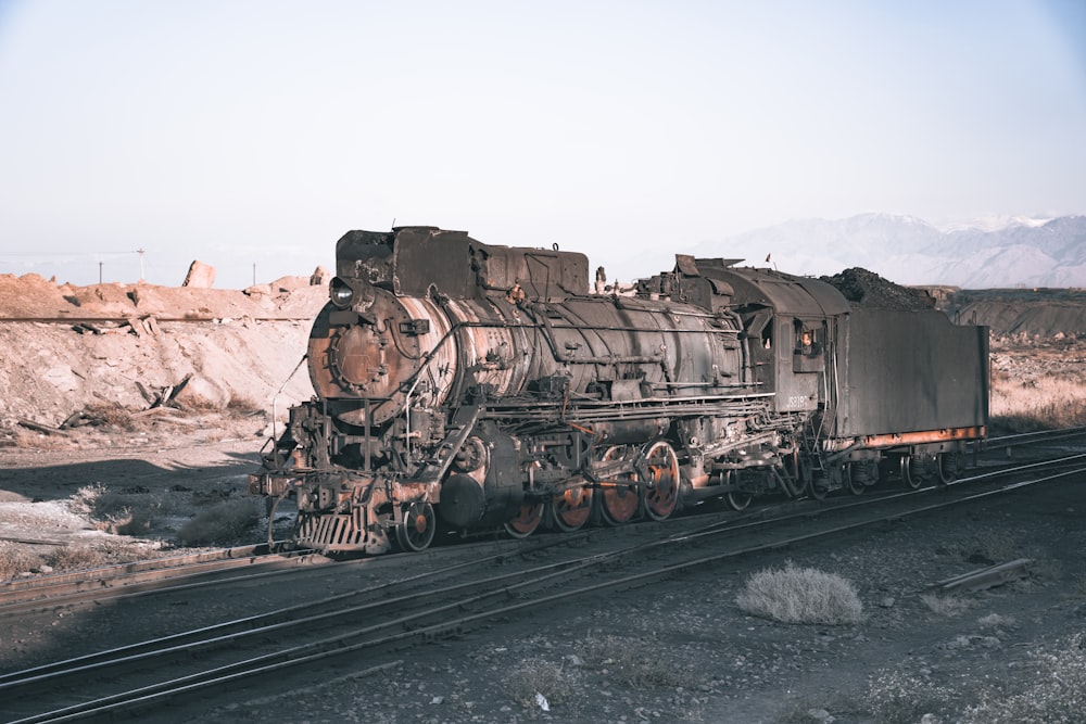 an old train sitting on the tracks in the desert