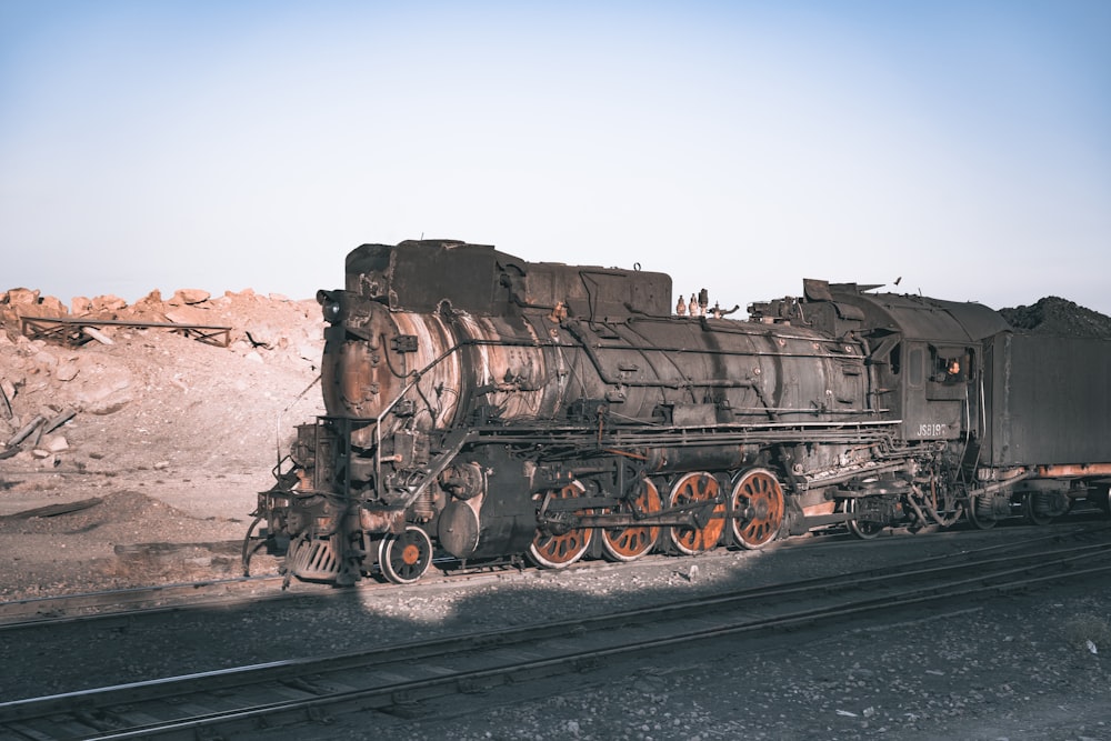 an old train sitting on the tracks in the desert