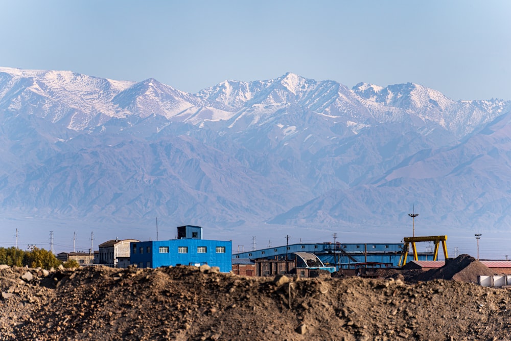 a blue building sitting on top of a dirt hill