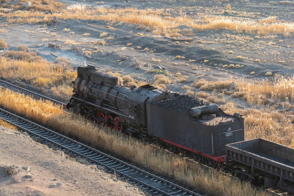 a train traveling down train tracks next to a field