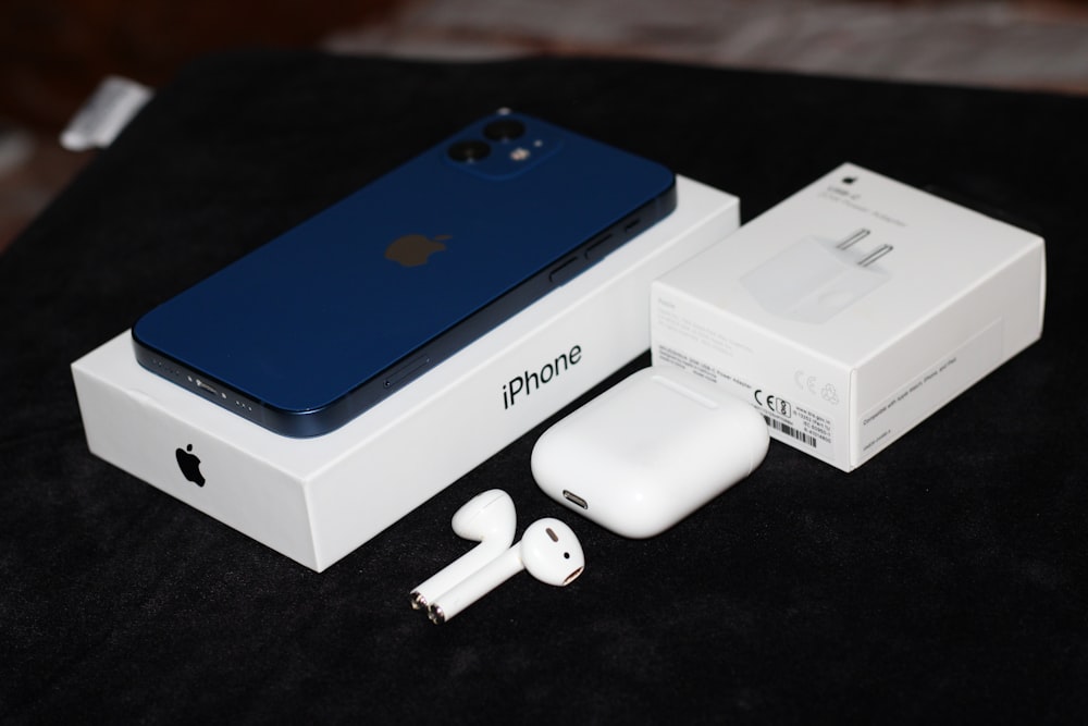 a box with an iphone and ear buds sitting next to it