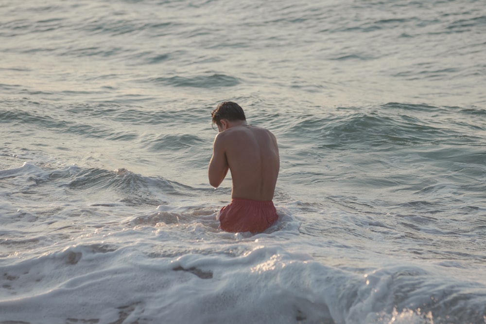 a man sitting on top of a surfboard in the ocean