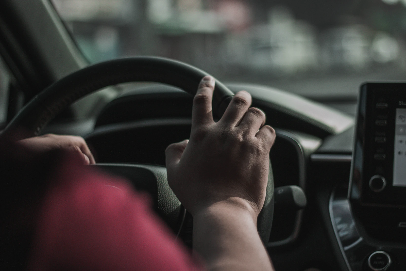 Mano sobre el volante de un vehículo en movimiento