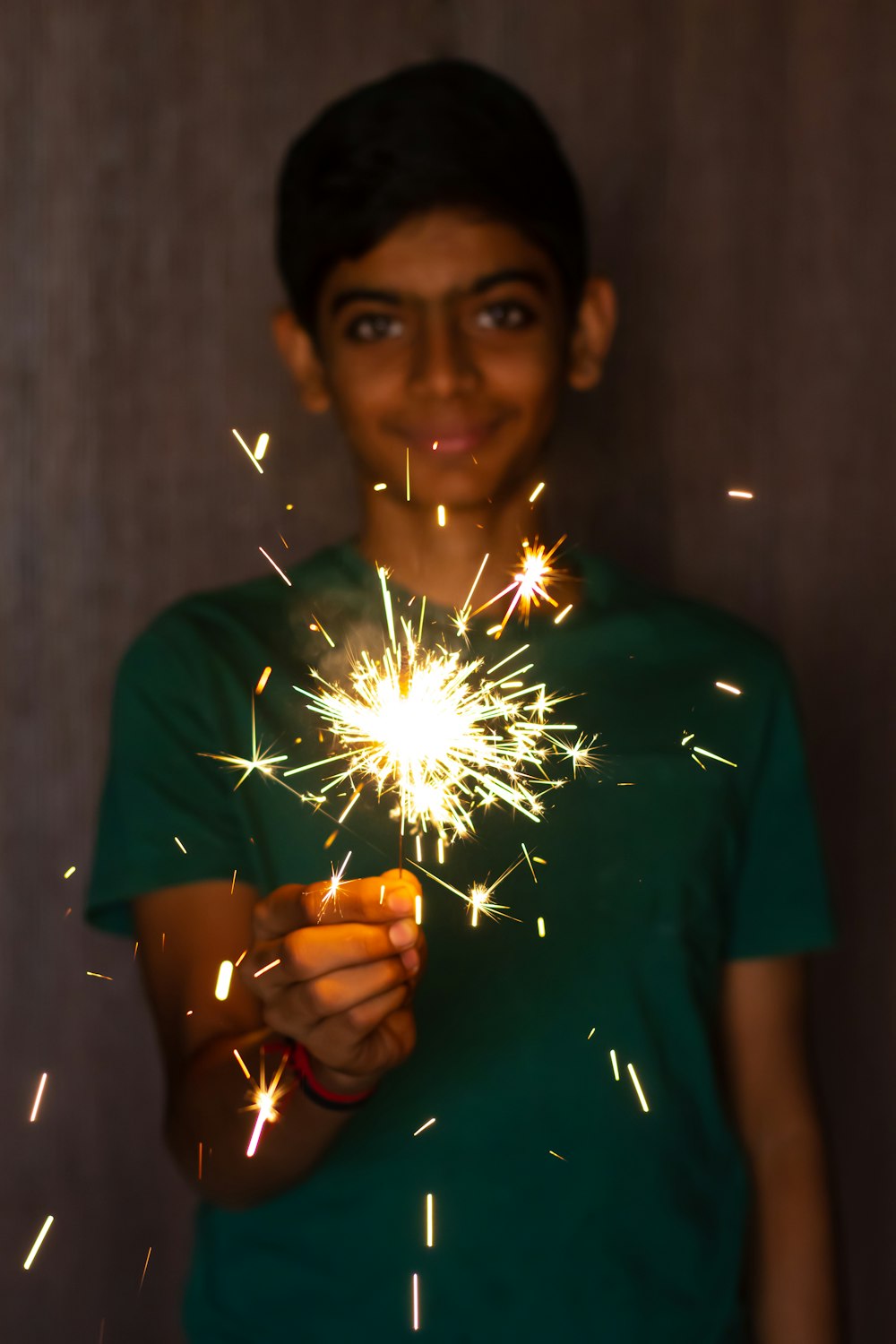 a young boy holding a sparkler in his hands
