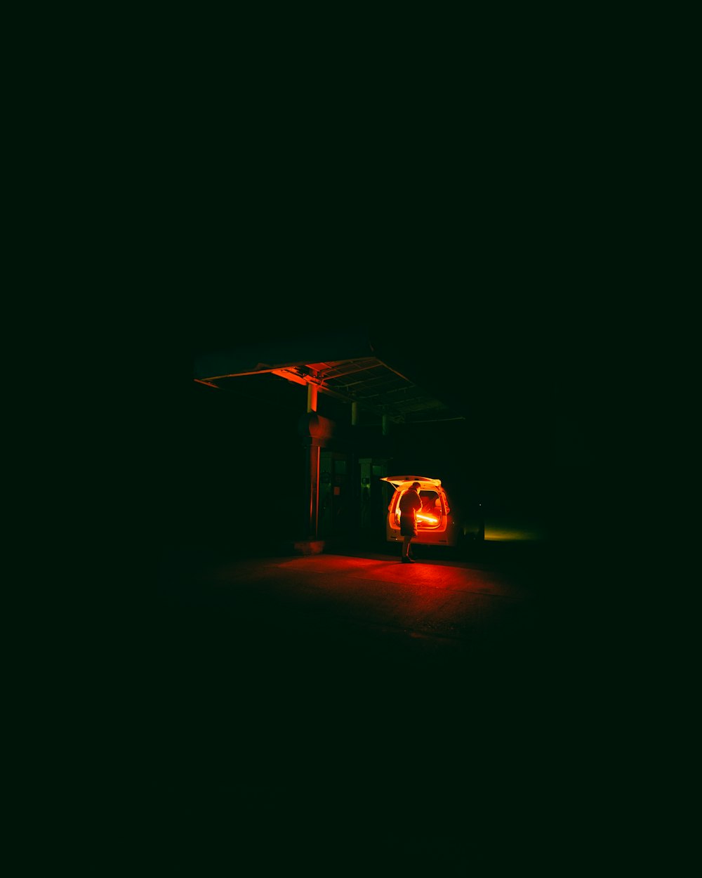 a red light shines on a gas station at night