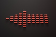 a group of red arrows on a black surface
