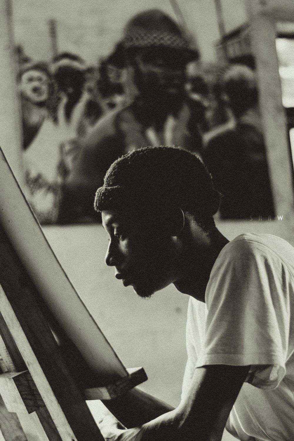 a man sitting in front of a painting on a easel