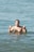 a man standing in the water giving a peace sign