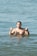 a man standing in the water giving a peace sign