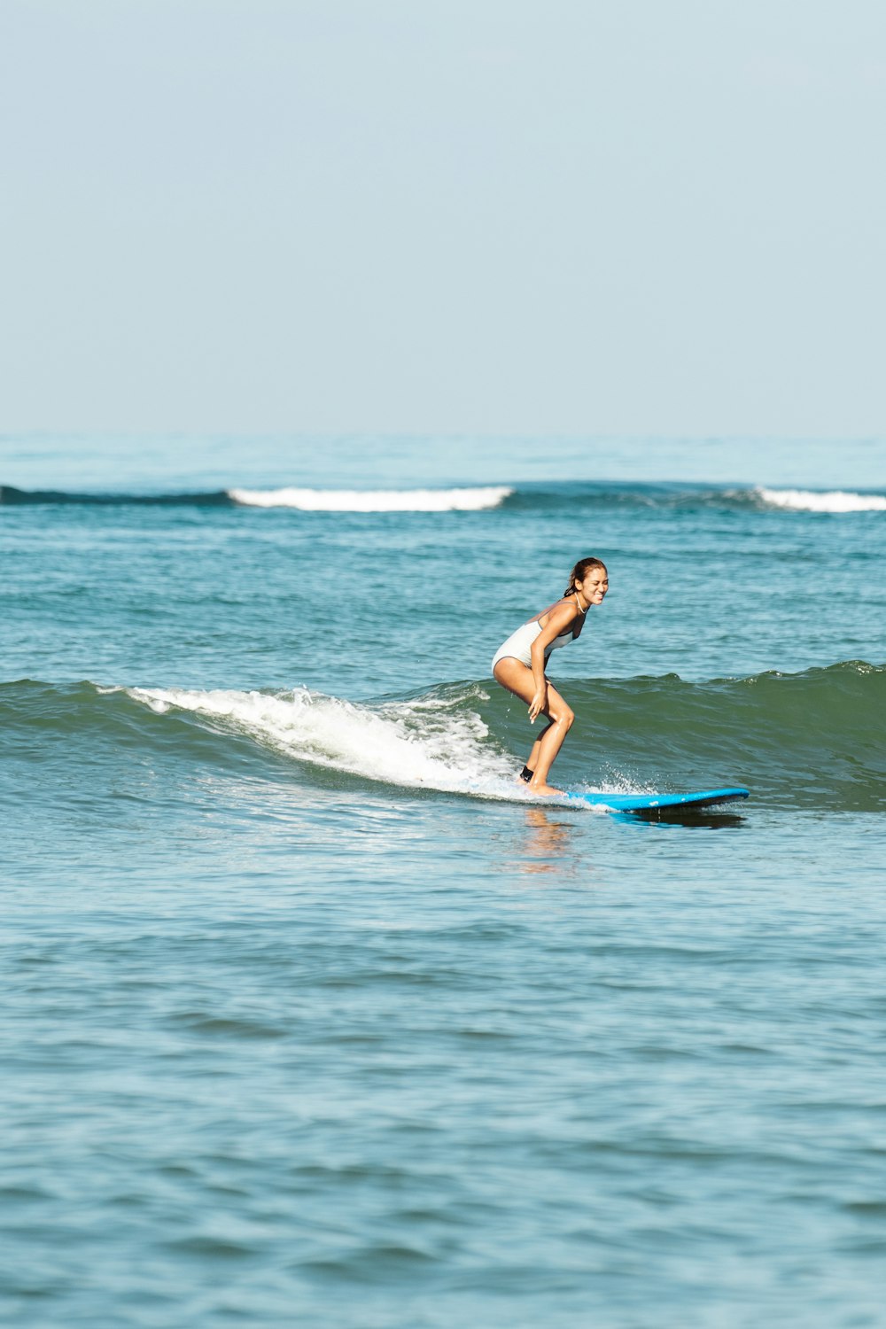 a woman riding a wave on top of a surfboard