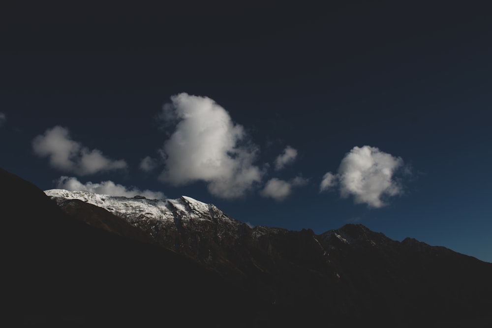 a view of a mountain with clouds in the sky