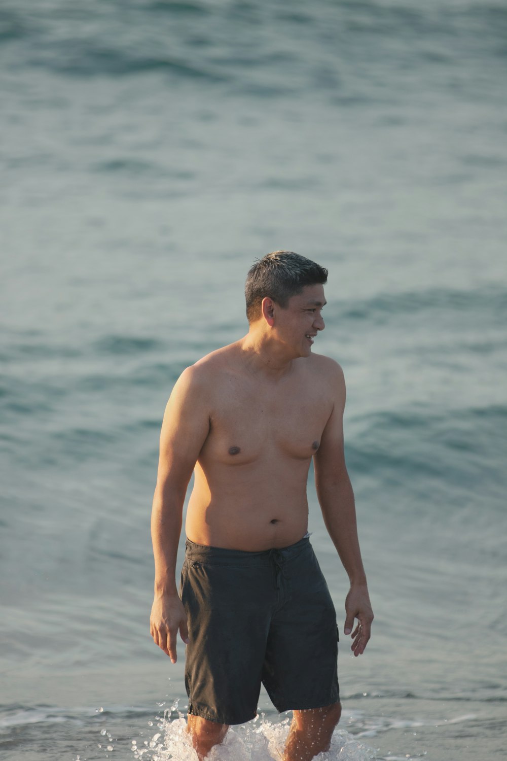 a man standing in the water at the beach