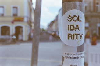 a sticker on a pole on a city street