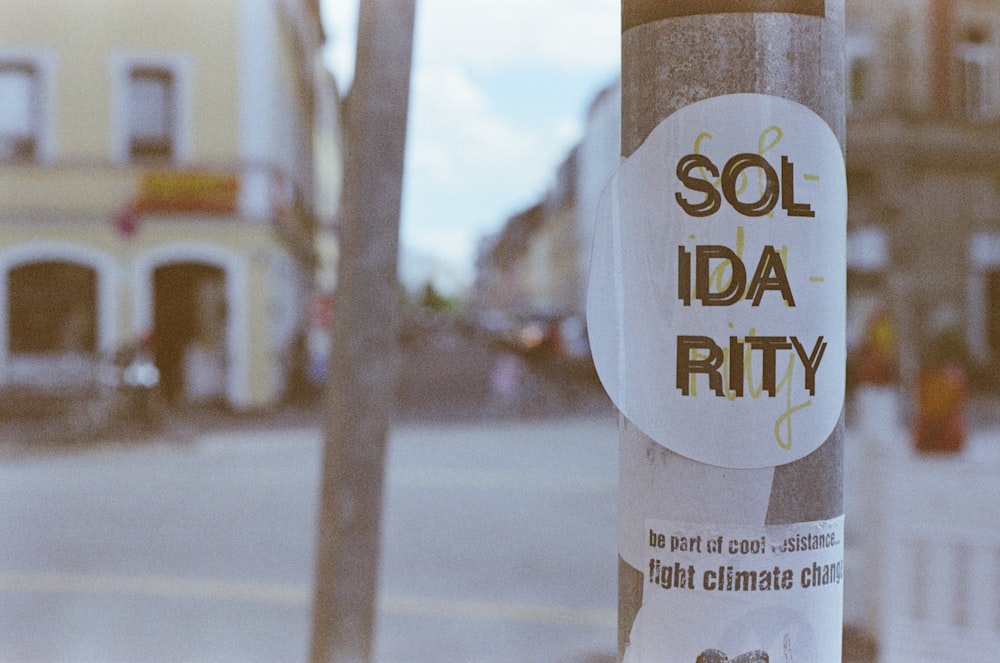 a sticker on a pole on a city street