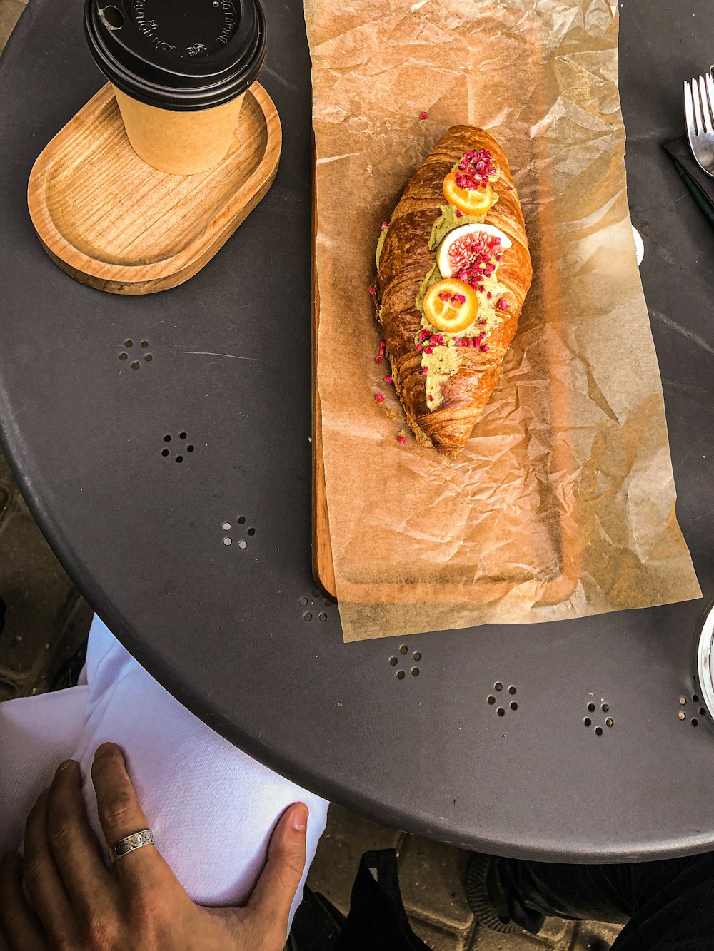 a croissant sitting on top of a table next to a cup of coffee