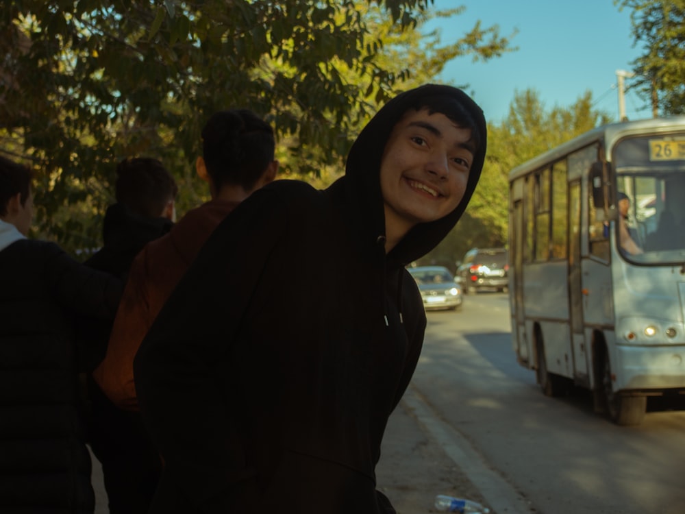 a man standing in front of a bus on a street