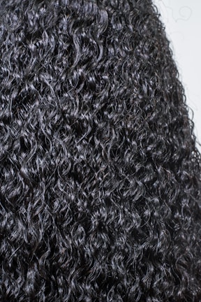 Close-up of a sleek, natural-looking wig with soft curls.