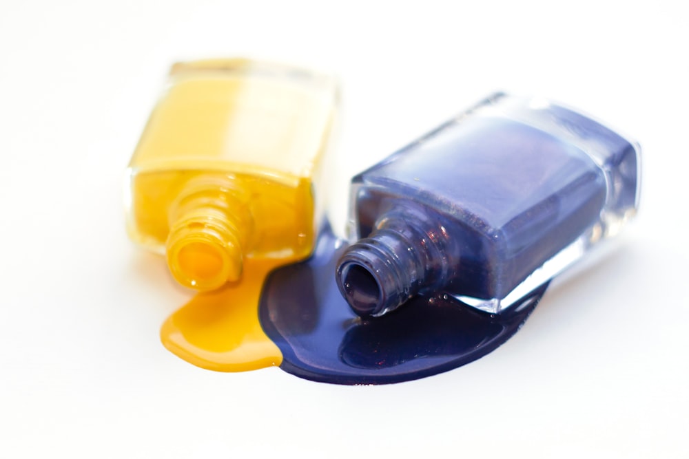 una botella de esmalte de uñas amarillo y azul