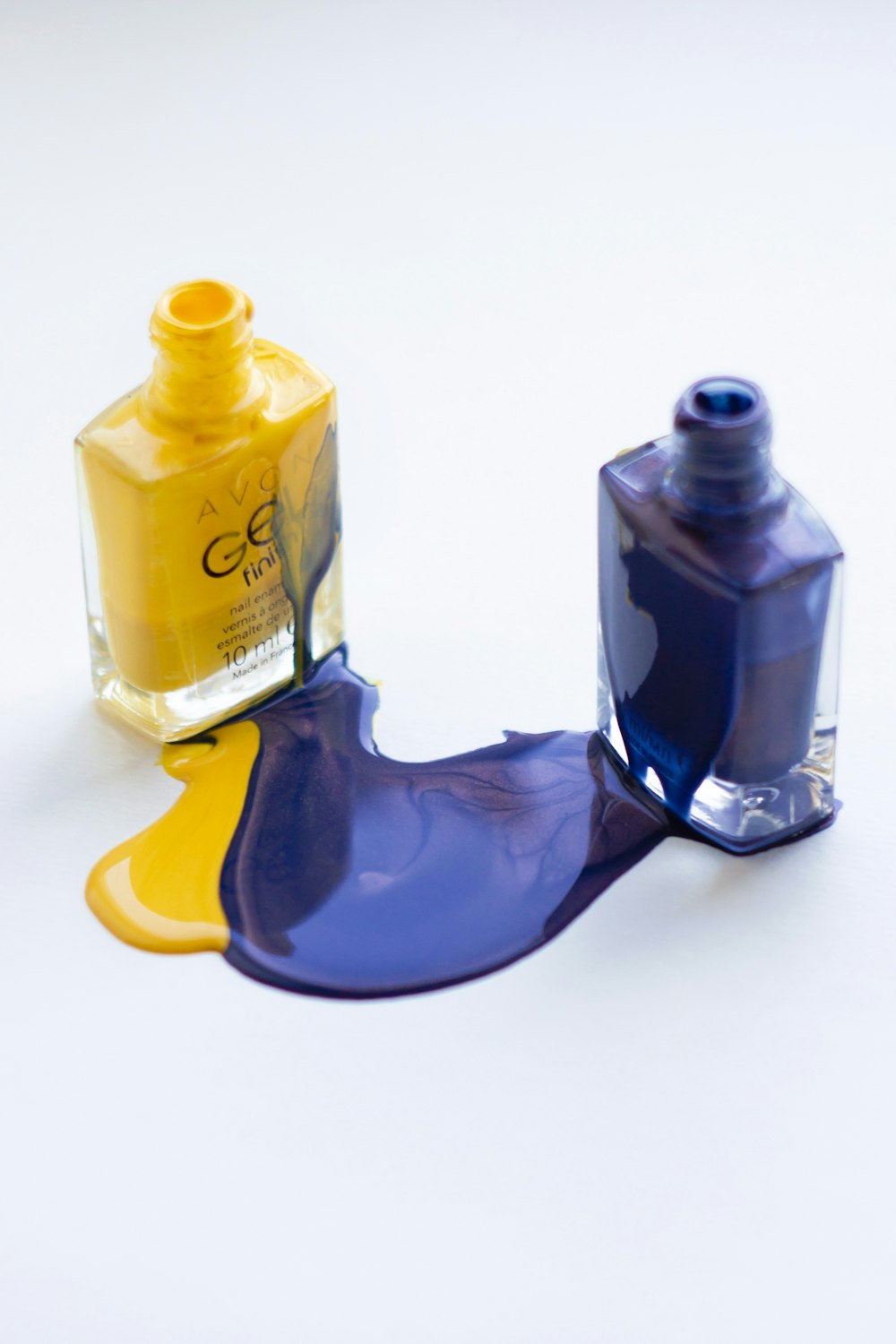 uma garrafa de tinta amarela e azul ao lado de uma garrafa de tinta azul e amarela